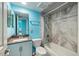 Well-lit bathroom with blue walls, a marble-tiled shower, and a vanity with a sink and storage at 116 Vista Hermosa Cir # 204C, Sarasota, FL 34242
