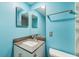 Bright blue bathroom featuring a vanity with a sink and mirror, alongside a towel rack and toilet at 116 Vista Hermosa Cir # 204C, Sarasota, FL 34242