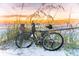 Serene beach scene with a bicycle leaning against a post at sunset at 116 Vista Hermosa Cir # 204C, Sarasota, FL 34242