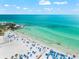 Aerial shot of a vibrant beach scene with umbrellas, clear water, and people enjoying the sun at 116 Vista Hermosa Cir # 204C, Sarasota, FL 34242