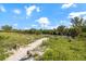 Picturesque beach path with rope railings leading through lush vegetation towards the sandy shoreline at 116 Vista Hermosa Cir # 204C, Sarasota, FL 34242