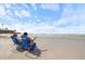 Beach scene with two women relaxing in blue beach chairs, looking at the ocean at 116 Vista Hermosa Cir # 204C, Sarasota, FL 34242