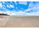Expansive view of a sandy beach with calm waters and clear skies in a waterfront community at 116 Vista Hermosa Cir # 204C, Sarasota, FL 34242
