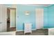 Light-filled bedroom with blue walls, featuring twin beds, a dresser, and a glimpse into the hallway at 116 Vista Hermosa Cir # 204C, Sarasota, FL 34242