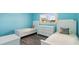 Bright, airy bedroom with two twin beds, a white dresser, and a window overlooking the landscape at 116 Vista Hermosa Cir # 204C, Sarasota, FL 34242