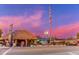 Tropical restaurant exterior featuring a thatched roof and vibrant evening sky at 116 Vista Hermosa Cir # 204C, Sarasota, FL 34242