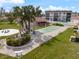 Community area featuring shuffleboard, picnic tables, grill, fountain, and meticulously landscaped grounds at 116 Vista Hermosa Cir # 204C, Sarasota, FL 34242