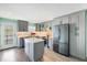 Modern kitchen with stainless steel appliances, gray cabinets and a center island with quartz countertops at 116 Vista Hermosa Cir # 204C, Sarasota, FL 34242