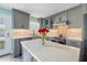Modern kitchen featuring gray cabinets, quartz countertops, stainless steel appliances, and an island at 116 Vista Hermosa Cir # 204C, Sarasota, FL 34242