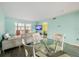 Sunlit living room with sleek furniture, a dining table, and a view of the patio through sliding glass doors at 116 Vista Hermosa Cir # 204C, Sarasota, FL 34242