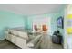 Bright living room features a modern sofa, gray flooring, and a sliding glass door to the patio at 116 Vista Hermosa Cir # 204C, Sarasota, FL 34242
