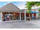 Outdoor dining area with tiki hut roof and string lights at 116 Vista Hermosa Cir # 204C, Sarasota, FL 34242