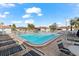 Community pool with lounge chairs and beautiful sunny skies at 116 Vista Hermosa Cir # 204C, Sarasota, FL 34242