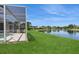 Beautiful backyard featuring a screened-in lanai, green grass and a tranquil lake view at 12007 Clubhouse Dr, Lakewood Ranch, FL 34202
