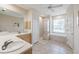 Bright bathroom features tile floors, double sink vanity, soaking tub and separate glass shower at 12007 Clubhouse Dr, Lakewood Ranch, FL 34202