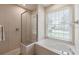Close up of bathroom, featuring glass shower, and soaking tub with views from the window at 12007 Clubhouse Dr, Lakewood Ranch, FL 34202