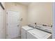 Laundry room with white washer and dryer and a door to additional storage at 12007 Clubhouse Dr, Lakewood Ranch, FL 34202
