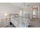 Bright main bedroom with paisley bedspread, ceiling fan, and views to the ensuite bathroom at 12007 Clubhouse Dr, Lakewood Ranch, FL 34202