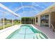 Screened-in pool featuring a spa, covered seating and view of the lake at 12007 Clubhouse Dr, Lakewood Ranch, FL 34202