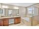 Bathroom featuring double sinks, a soaking tub, and a glass shower at 12214 Streambed Dr, Riverview, FL 33579