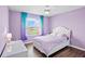 Bedroom with lavender walls, wood floors, and a white upholstered bed at 12214 Streambed Dr, Riverview, FL 33579