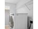 Laundry room with white washer and dryer and overhead wire shelving at 12214 Streambed Dr, Riverview, FL 33579