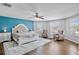 Spacious main bedroom with wood floors, sitting area, ceiling fan, and a blue accent wall at 12214 Streambed Dr, Riverview, FL 33579
