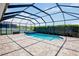 Relaxing screened-in pool and spa area with brick pavers and blue tile accents at 12214 Streambed Dr, Riverview, FL 33579