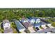 Aerial shot featuring a neighborhood with lush trees, houses with driveways and cars parked in front at 12520 Shimmering Oak Cir, Venice, FL 34293