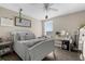 Well-lit bedroom featuring neutral walls, ceiling fan, and a cozy bed with ample pillows and decor at 12520 Shimmering Oak Cir, Venice, FL 34293