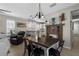 Well-lit dining space with a rustic table, modern lighting, and an open view of the kitchen and living area at 12520 Shimmering Oak Cir, Venice, FL 34293