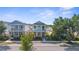 Charming two-story home showcasing a front porch, lush landscaping, and proximity to neighboring houses at 12520 Shimmering Oak Cir, Venice, FL 34293