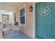 Inviting front porch featuring rocking chairs, coastal decor, and a charming blue front door at 12520 Shimmering Oak Cir, Venice, FL 34293
