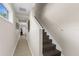 Inviting hallway featuring tiled floors leading to stairs with hardwood treads and bright, neutral wall color at 12520 Shimmering Oak Cir, Venice, FL 34293