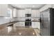 Modern kitchen featuring stainless steel refrigerator and white cabinets at 12520 Shimmering Oak Cir, Venice, FL 34293