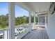 A cozy, covered porch with white columns offers a relaxing outdoor space and neighborhood views at 12520 Shimmering Oak Cir, Venice, FL 34293