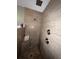 Modern bathroom featuring stone look tile walls, a pebble shower floor, and dual shower heads at 14432 Mcclellan Ave, Port Charlotte, FL 33953