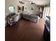 Spacious living room with hardwood floors, a ceiling fan, and a pass-through window to the kitchen at 14432 Mcclellan Ave, Port Charlotte, FL 33953