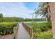 A wooden dock extends into a serene waterway surrounded by lush, green mangroves, offering a peaceful escape at 1609 Bayhouse Point Dr # 232, Sarasota, FL 34231
