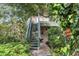 Two-story home with a wooden staircase and a balcony surrounded by lush, mature greenery at 1609 Bayhouse Point Dr # 232, Sarasota, FL 34231