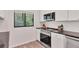Updated kitchen with white cabinets, stone countertops, and stainless steel appliances for modern cooking at 1609 Bayhouse Point Dr # 232, Sarasota, FL 34231