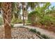 A gravel pathway winds through a lush garden featuring palm trees, shrubs, and decorative rock borders at 1609 Bayhouse Point Dr # 232, Sarasota, FL 34231