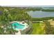 Aerial view of a community pool surrounded by lush tropical landscaping and waterfront views at 1609 Bayhouse Point Dr # 232, Sarasota, FL 34231