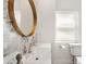 Bathroom with a modern sink, decorative wallpaper, and a round mirror at 174 Golden Gate Pt # 21, Sarasota, FL 34236