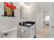 Clean, well-lit bathroom with black granite sink and adjacent bedroom at 174 Golden Gate Pt # 21, Sarasota, FL 34236