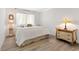 Bedroom with wood-look floors, white walls and curtains, and vintage end tables at 174 Golden Gate Pt # 21, Sarasota, FL 34236