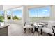 Bright dining area with a modern table setting and stunning waterfront views through large windows at 174 Golden Gate Pt # 21, Sarasota, FL 34236