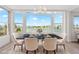Elegant dining area with waterfront view, marble table and comfortable seating at 174 Golden Gate Pt # 21, Sarasota, FL 34236