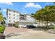 Modern multi-story building featuring assigned parking, brick driveway and manicured landscaping at 174 Golden Gate Pt # 21, Sarasota, FL 34236