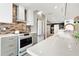Kitchen featuring stainless appliances, gray cabinets, white countertops, and subway tile backsplash at 174 Golden Gate Pt # 21, Sarasota, FL 34236